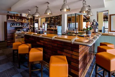 a bar in a restaurant with orange bar stools at Villa Pinetree Seaside, Albufeira in Albufeira