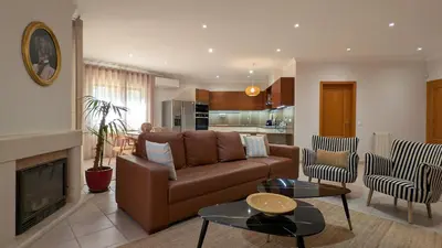 a living room with a couch and a fireplace at Villa Pinetree Seaside, Albufeira in Albufeira