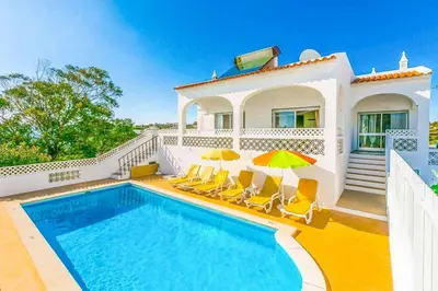 a villa with a swimming pool in front of a house at Casa Barreto in Albufeira