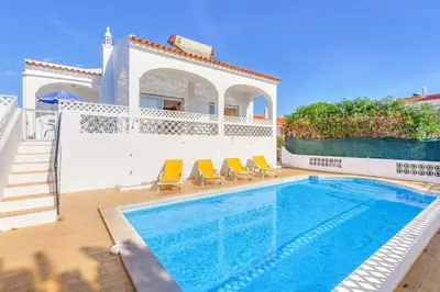a villa with a swimming pool next to a house at Casa Barreto in Albufeira