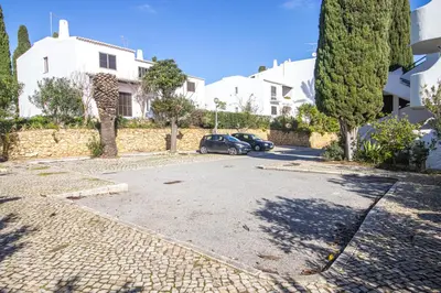 a car parked in a parking lot next to a house at Seaside Retreat with Pool, AC, and Fast Wi-Fi in Albufeira