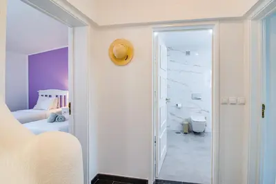 a white room with a bed and a bathroom at Seaside Retreat with Pool, AC, and Fast Wi-Fi in Albufeira