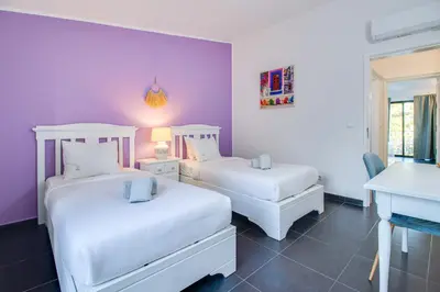 two beds in a room with purple walls at Seaside Retreat with Pool, AC, and Fast Wi-Fi in Albufeira