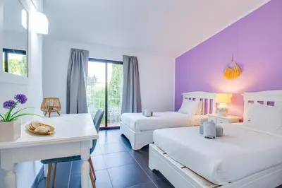 a hotel room with two beds and a table at Seaside Retreat with Pool, AC, and Fast Wi-Fi in Albufeira