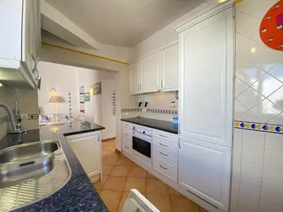 a kitchen with white cabinets and a sink at Albufeira Quinta da Balaia Charming by Homing in Albufeira