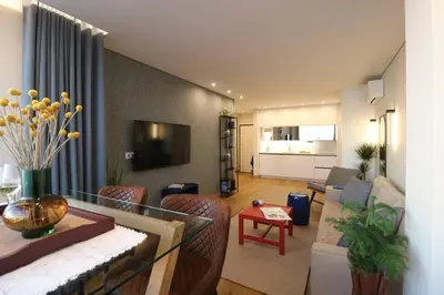 a living room with a couch and a table and a television at Blue over blue in Quarteira