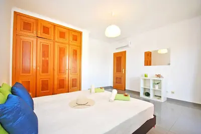 a living room with a bed and a blue couch at Apartment Ipanema 1 by Algarve Vacation in Albufeira
