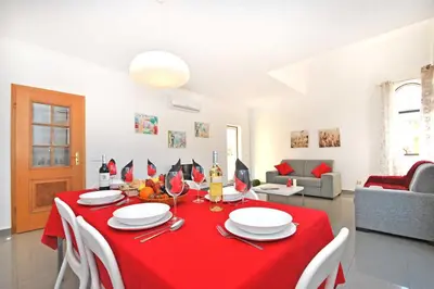 a living room with a table with a red table cloth at Apartment Ipanema 1 by Algarve Vacation in Albufeira