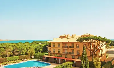 a large building with a swimming pool in front of it at Apartment Ipanema 2 by Algarve Vacation in Albufeira