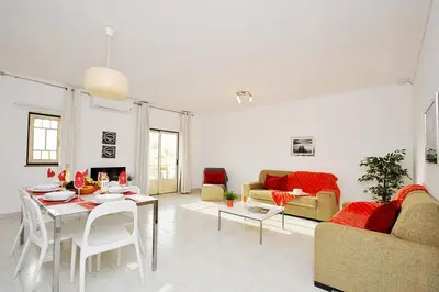 a white living room with a table and chairs at Apartment Ipanema 2 by Algarve Vacation in Albufeira