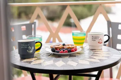 a table with a plate of food and coffee cups at Peaceful 1 BDR Apartment W/ Balcony by LovelyStay in Almancil