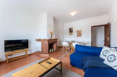 a living room with a blue couch and a tv at Peaceful 1 BDR Apartment W/ Balcony by LovelyStay in Almancil