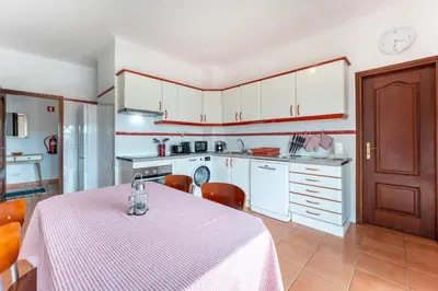 a kitchen with a table with a pink table cloth at Peaceful 1 BDR Apartment W/ Balcony by LovelyStay in Almancil