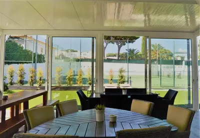 a dining room with a table and chairs and a large window at Villa | w/ Private Pool, Tennis Courts & Golf Putt in Vilamoura