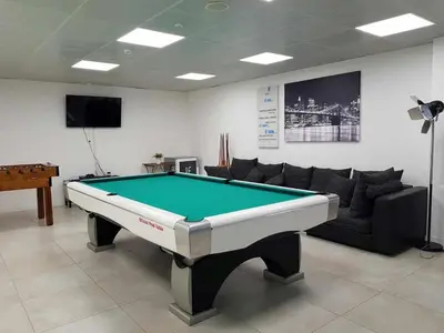 a living room with a pool table and a couch at Villa | w/ Private Pool, Tennis Courts & Golf Putt in Vilamoura