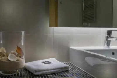 a bathroom with a sink and a counter with towels at Villa | w/ Private Pool, Tennis Courts & Golf Putt in Vilamoura