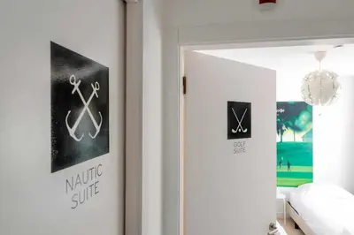 a living room with a white couch and posters on the wall at Villa | w/ Private Pool, Tennis Courts & Golf Putt in Vilamoura