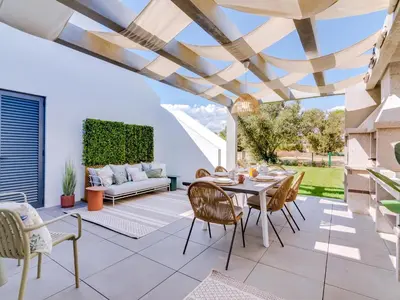 a patio with a table and chairs and a couch at AL - Boho Chic Villa Country Club in Vilamoura
