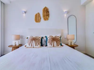 a bedroom with a large white bed with two lamps at AL - Boho Chic Villa Country Club in Vilamoura