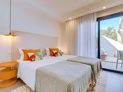 two beds in a room with a window at AL - Boho Chic Villa Country Club in Vilamoura
