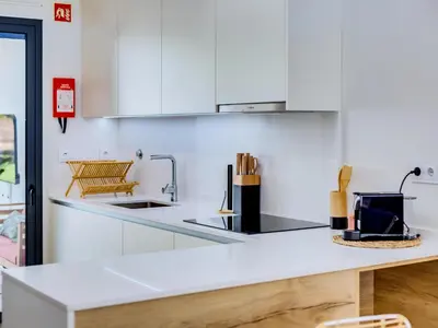a kitchen with white cabinets and a counter top at AL - Boho Chic Villa Country Club in Vilamoura