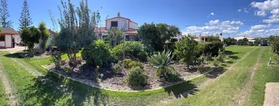 a garden with trees and plants in front of a house at Casa da Horta, Vale carro Olhos de Agua in Albufeira