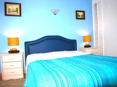 a blue bedroom with a bed and two lamps on night stands at Casa da Horta, Vale carro Olhos de Agua in Albufeira
