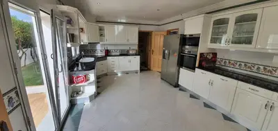 a kitchen with white cabinets and stainless steel appliances at Villa Arquete 6 seat Jacuzzi 5 min walk to shops in Guia