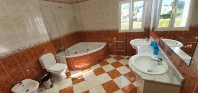 a bathroom with two sinks and a tub and a toilet at Villa Arquete 6 seat Jacuzzi 5 min walk to shops in Guia