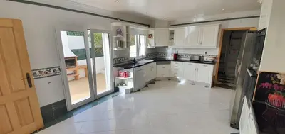 a kitchen with white cabinets and a large window at Villa Arquete 6 seat Jacuzzi 5 min walk to shops in Guia