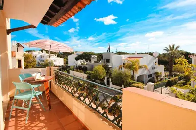a balcony with a table and chairs and a view of a city at Two bed Old Village E007 in Vilamoura