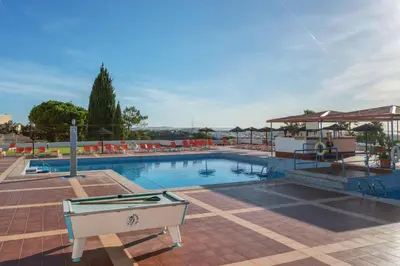 a bench sitting in the middle of a city street at BnB Homes Jardim Cozy Apartment with 3 Swimming pools near the Old Town in Albufeira