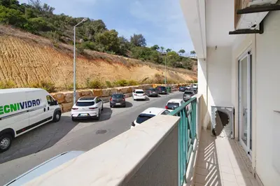 a balcony of a building with cars parked on a street at Apartamento do Sol in Albufeira