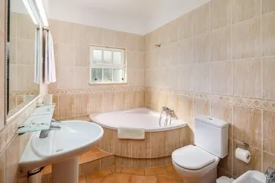 a bathroom with a tub and a toilet and a sink at 7 Bedroom Private Villa Tenazinha II, with pool in Albufeira