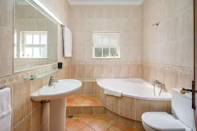 a bathroom with a tub and a toilet and a sink at 7 Bedroom Private Villa Tenazinha II, with pool in Albufeira