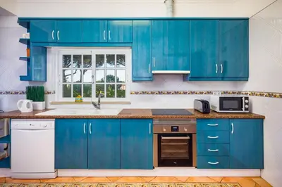 a kitchen with blue cabinets and a sink at 7 Bedroom Private Villa Tenazinha II, with pool in Albufeira