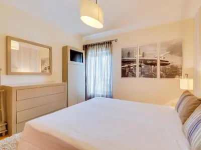 a bedroom with a large white bed and a window at AL - Apartamento Moura Praia in Vilamoura