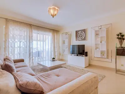 a living room with a couch and a tv at AL - Apartamento Moura Praia in Vilamoura