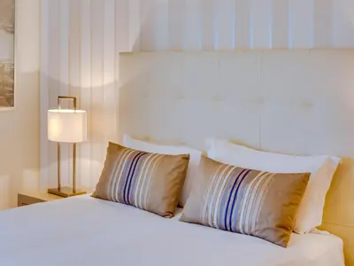 a bedroom with a bed with two pillows and a lamp at AL - Apartamento Moura Praia in Vilamoura