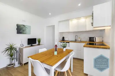 a kitchen with a wooden table and white cabinets at Vila Magna 109 - Dream Lodging in Albufeira
