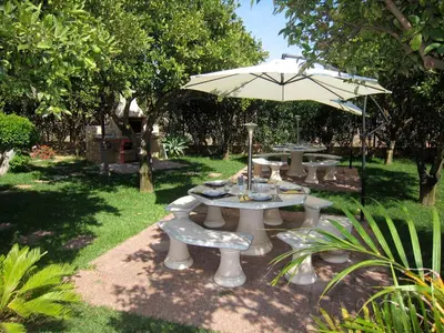 a group of tables and an umbrella in a yard at CH 8, 11 e 12 - Casa da Horta 3 x T 1 Apartments Up To 12 Guests in Olhos de Água