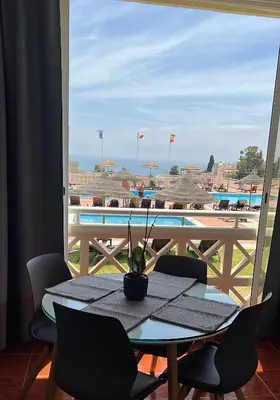 a table and chairs with a view of a pool at Albufeira studio Bellevista in Albufeira