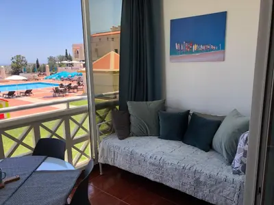 a couch in a room with a view of a pool at Albufeira studio Bellevista in Albufeira