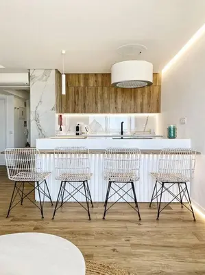 a kitchen with four chairs and a white counter at Front Sea Apartment Quarteira in Quarteira
