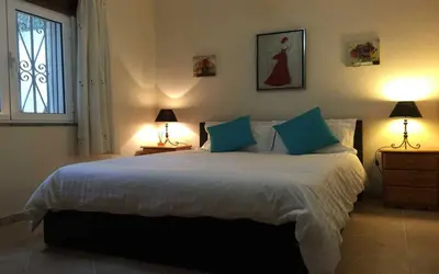 a bedroom with a large bed with blue pillows at Villa Oliandra in Vilamoura