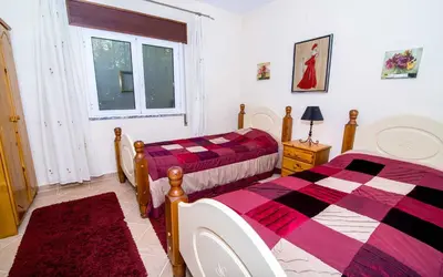 a bedroom with two beds and a window at Villa Oliandra in Vilamoura