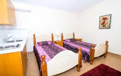 a small bedroom with two beds and a sink at Villa Oliandra in Vilamoura