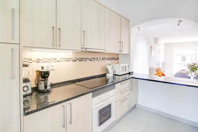 a kitchen with white cabinets and a counter top at Modern Oasis 500m Beach with AC WiFi Pool in Albufeira