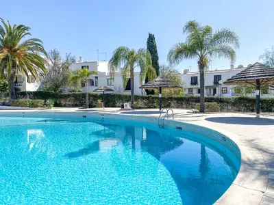 a swimming pool with palm trees and umbrellas at Modern Oasis 500m Beach with AC WiFi Pool in Albufeira