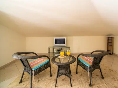 a room with two chairs and a table and a tv at Apartment Penthouse Milea by Interhome in Patroves